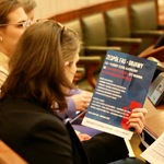 Uczestnik konferencji trzyma ulotkę informacyjną.
