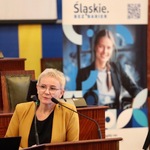 Prelegentka na mównicy na tle baneru Śląskie Bez Barier.