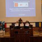 Trzy osoby trzymają plansze dotyczące Kampanii Dzieciństwo Bez Przemocy.