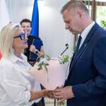 Marszałek Rafał Adamczyk wręcza kwiaty uczestniczce.