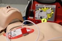 Fantom do nauki resuscytacji krążeniowo-oddechowej z podłączonym defibrylatorem  (AED). Na klatce piersiowej widoczne są elektrody defibrylatora używane podczas ćwiczeń pierwszej pomocy.