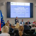 Pani Dorota Konieczny-Simela stoi przy stole prezydialnym i przemawia.