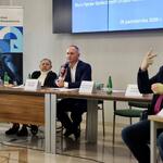 Przewodniczący Sejmiku siedzi za stołem prezydialnym i przemawia do mikrofonu.